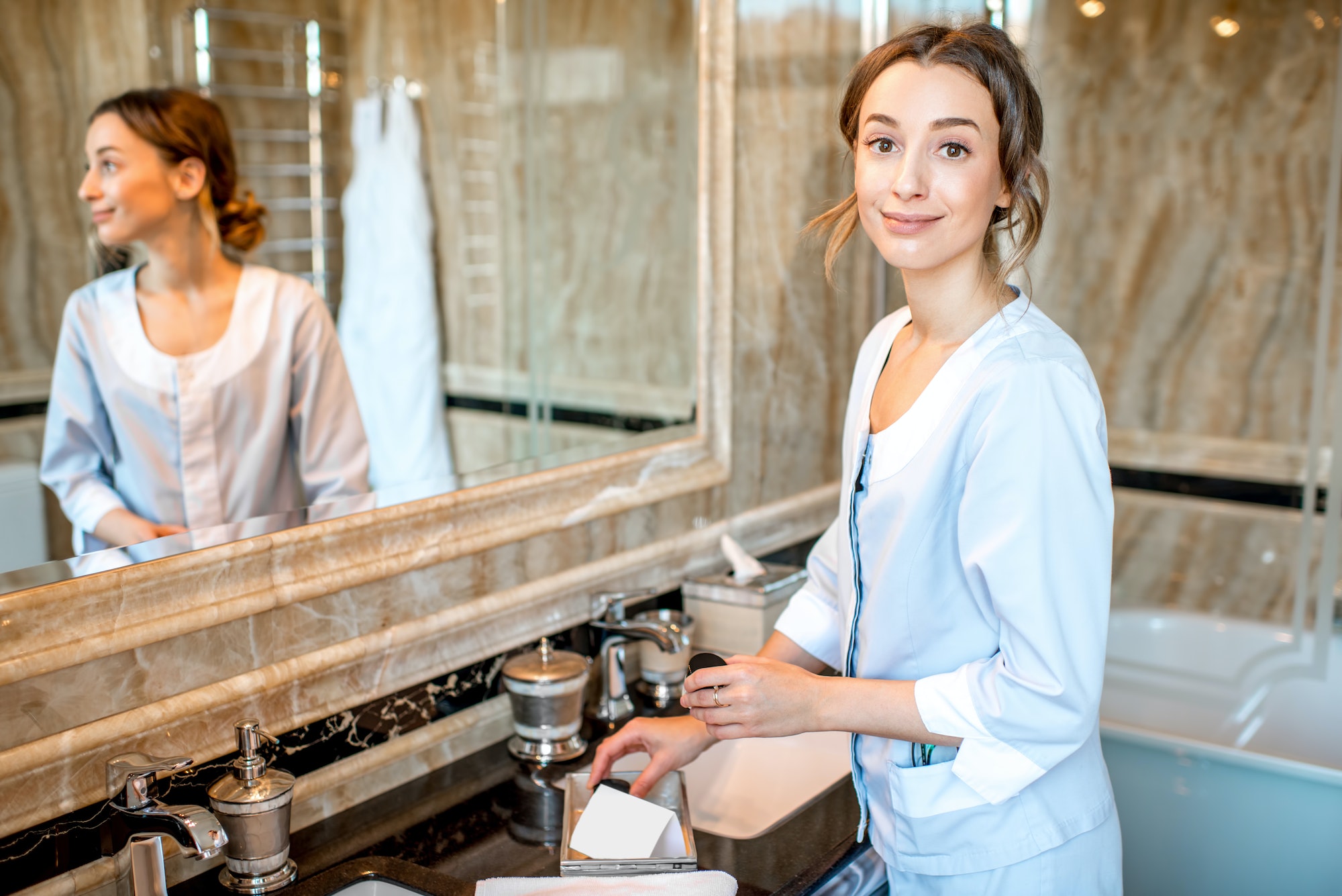 Chambermaid in the hotel bathroom